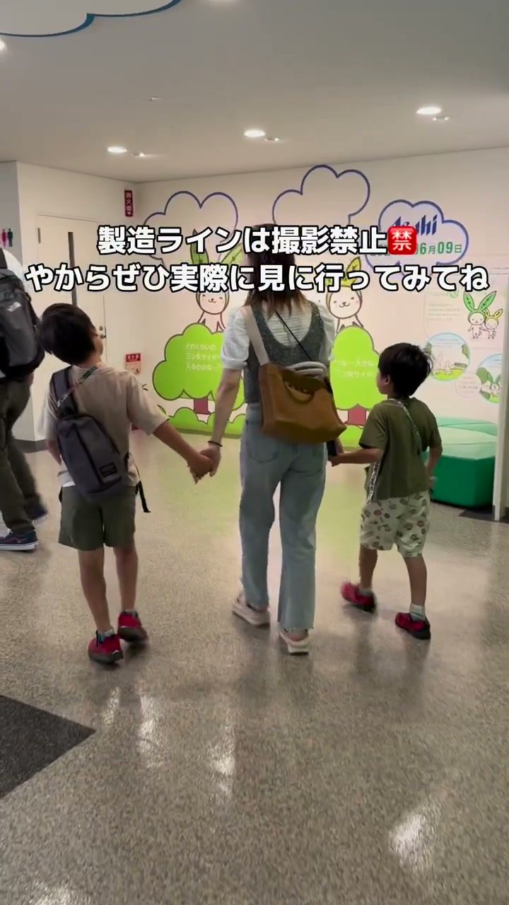 見学コースを手をつないで歩く親子の後ろ姿