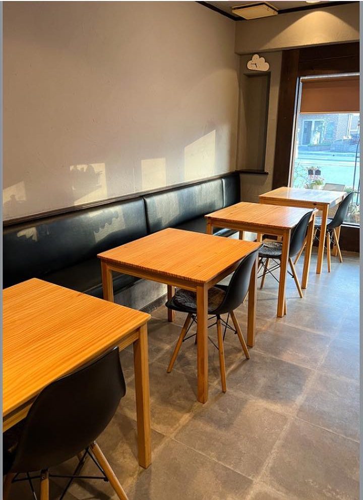 木のテーブル席とソファが並ぶ明るい店内