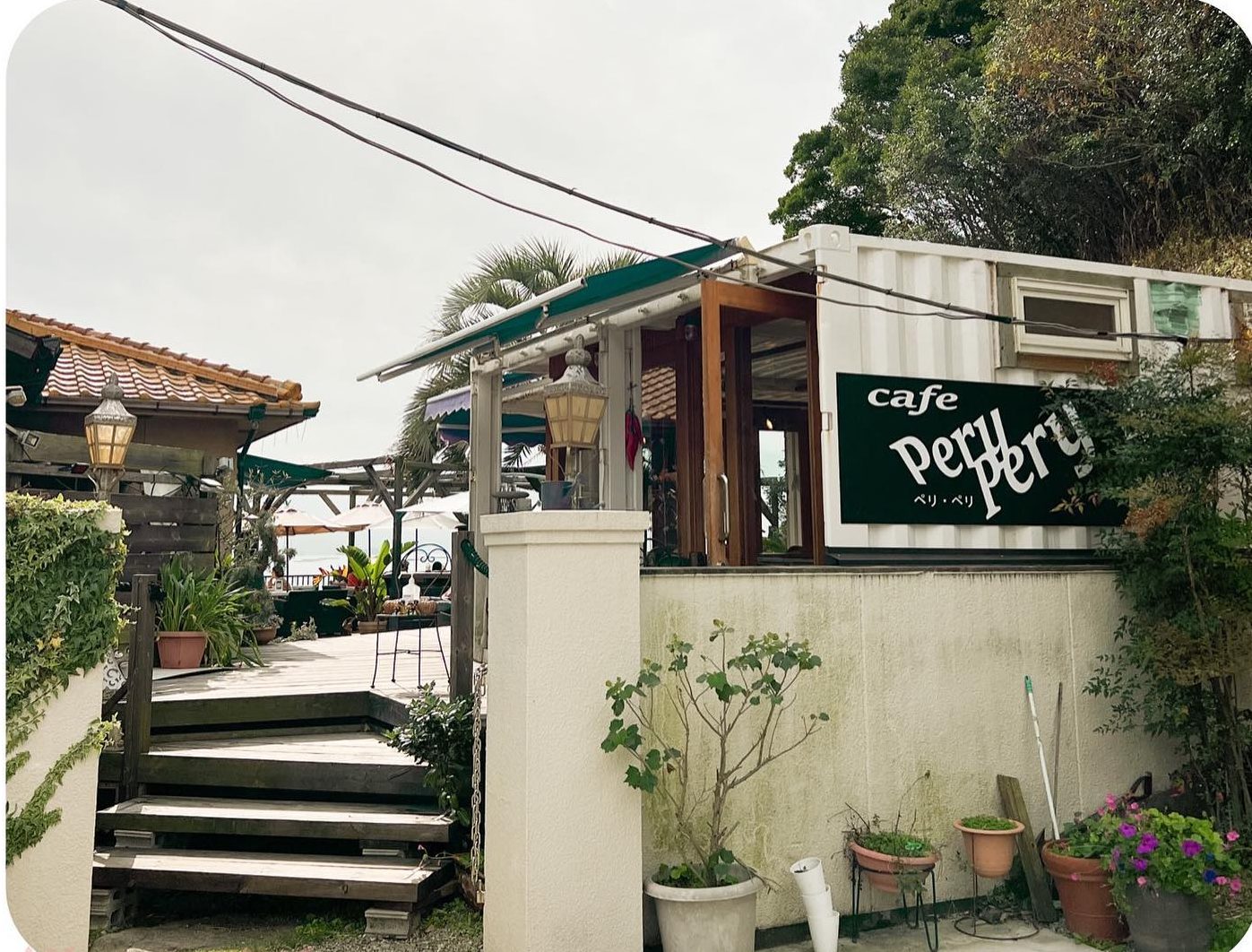緑に囲まれた階段の先にあるcafe Pery Peryの入り口