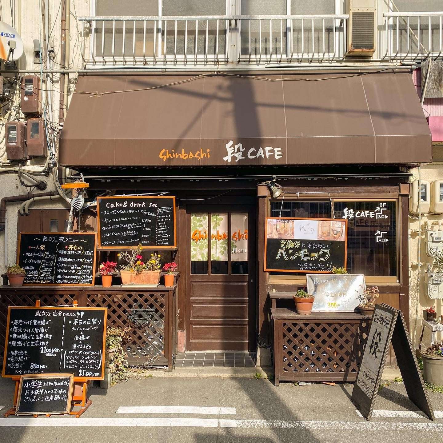 黒板メニューが並ぶ段カフェの外観