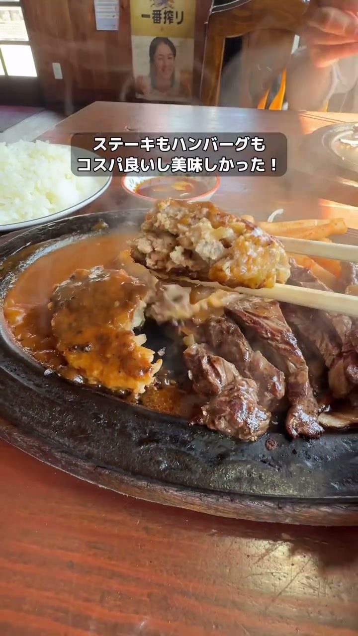 鉄板の上でジュウジュウと焼けるステーキとハンバーグ