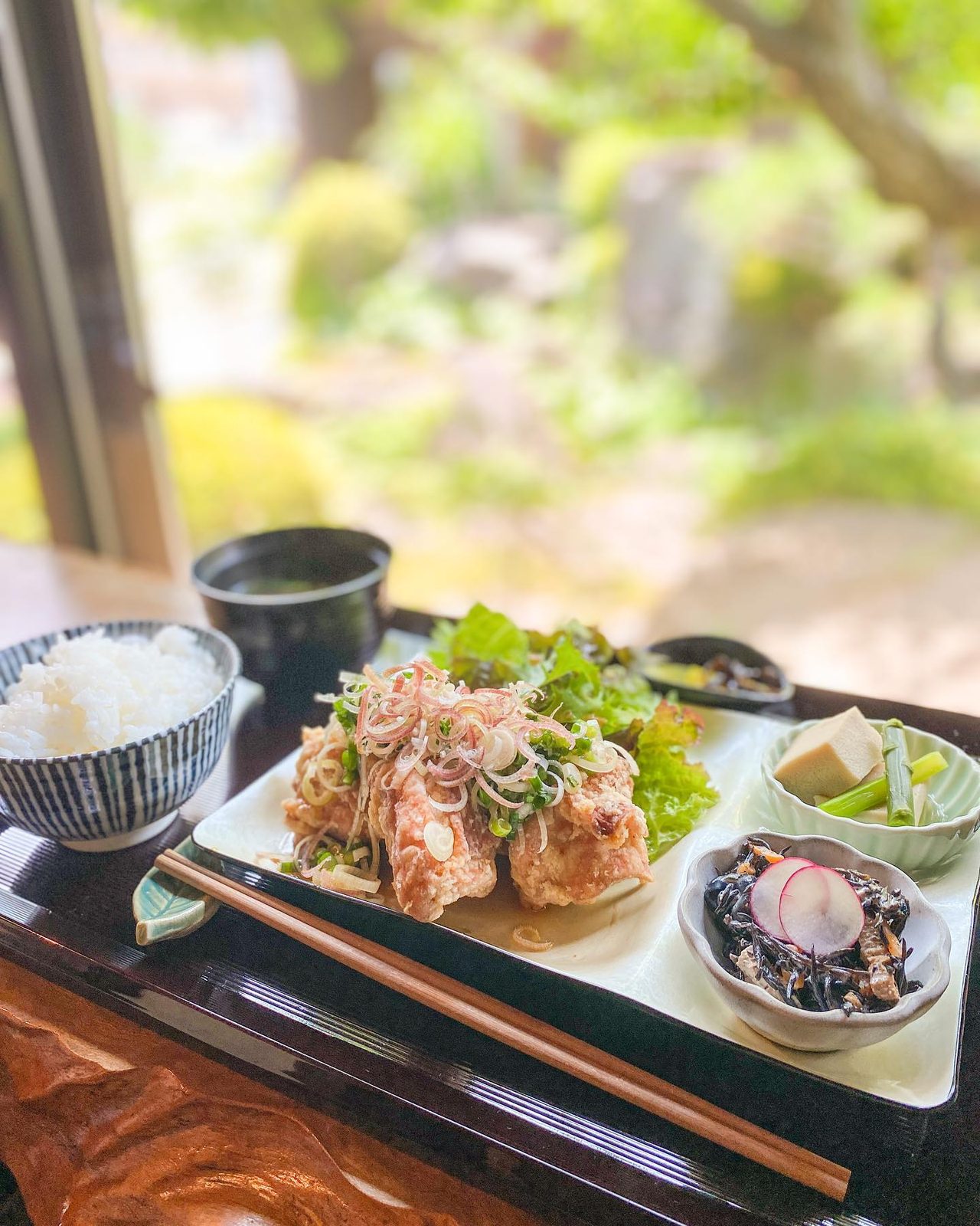 若鶏のからあげ定食に小鉢とご飯が並ぶランチ
