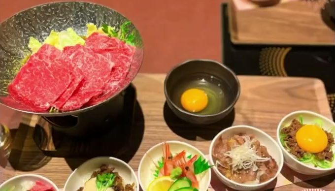 黒毛和牛のすき焼き鍋と小鉢の丼が並ぶ御膳