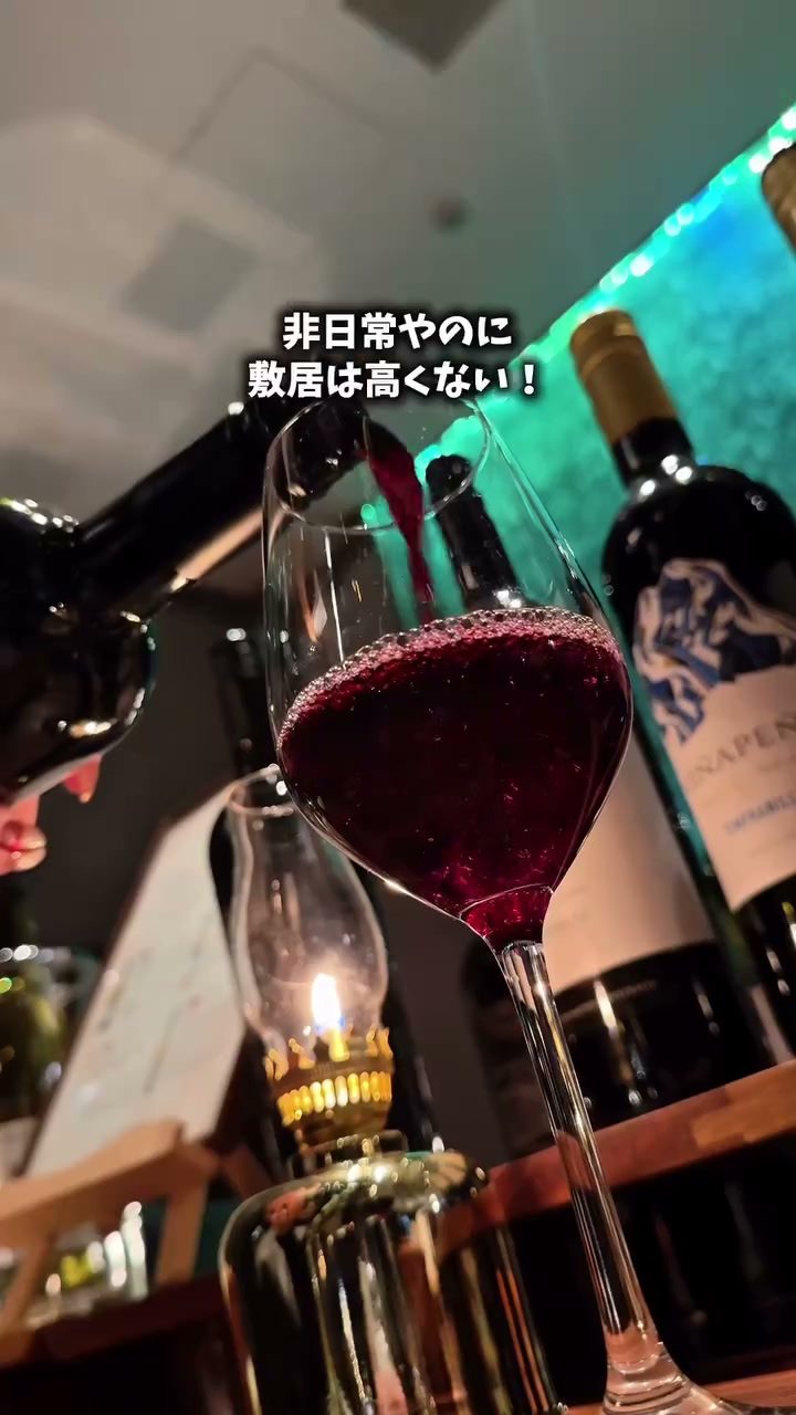 ランプの灯りのそばで注がれる赤ワイン