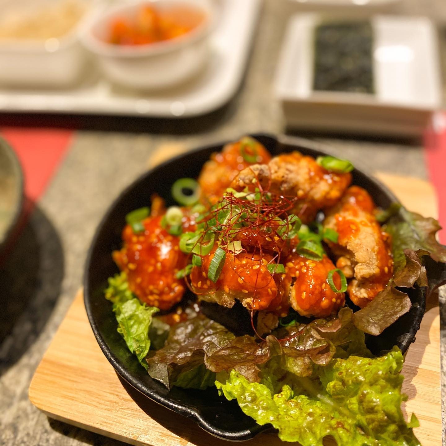 真っ赤なタレをからめたチキンをレタスの上に盛った鉄板料理