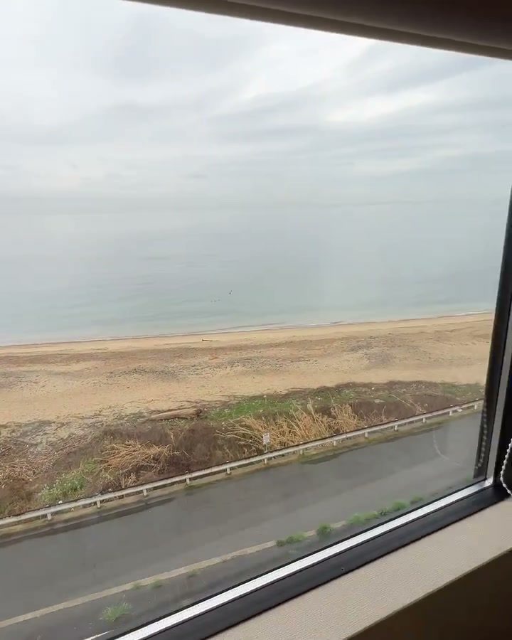 窓の向こうに広がる海と砂浜