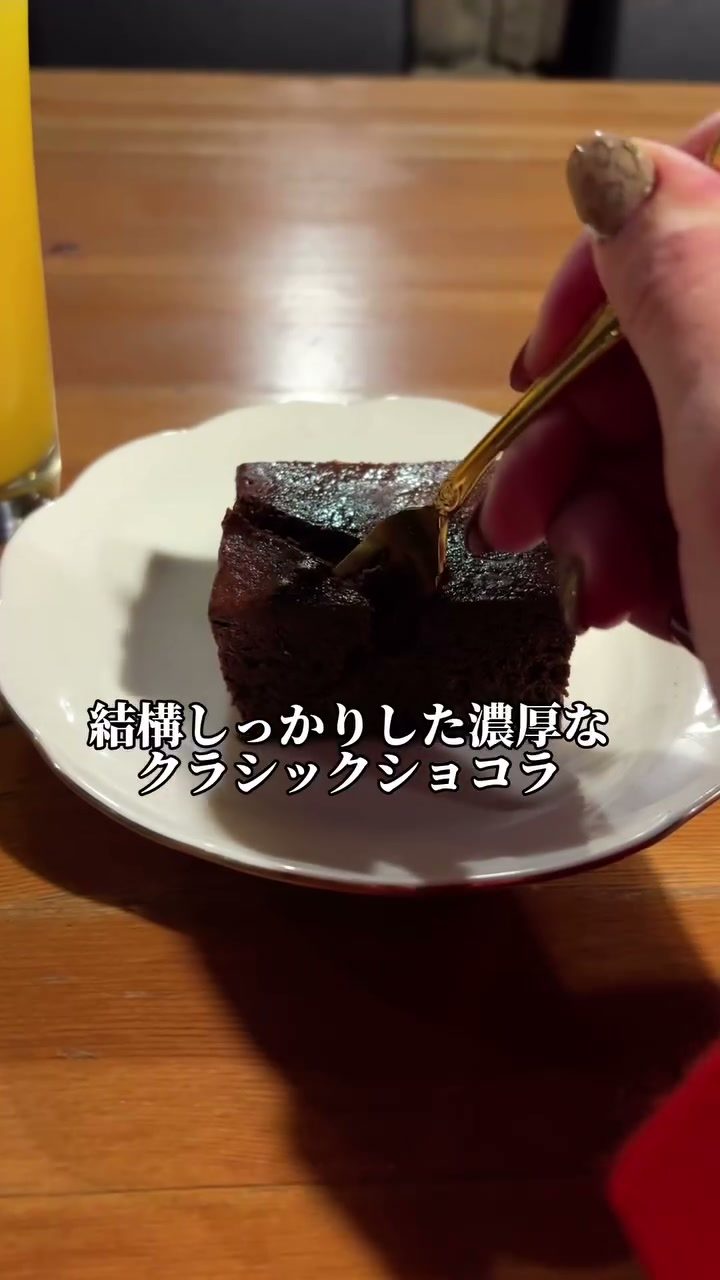 フォークを入れた濃厚なクラシックショコラとオレンジジュース