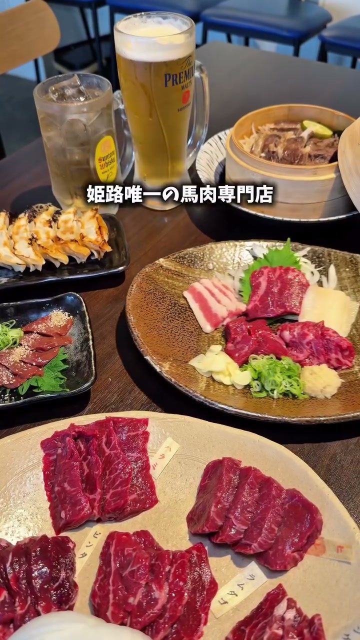 馬刺しや焼肉用の馬肉、餃子、せいろ蒸しが並ぶテーブル