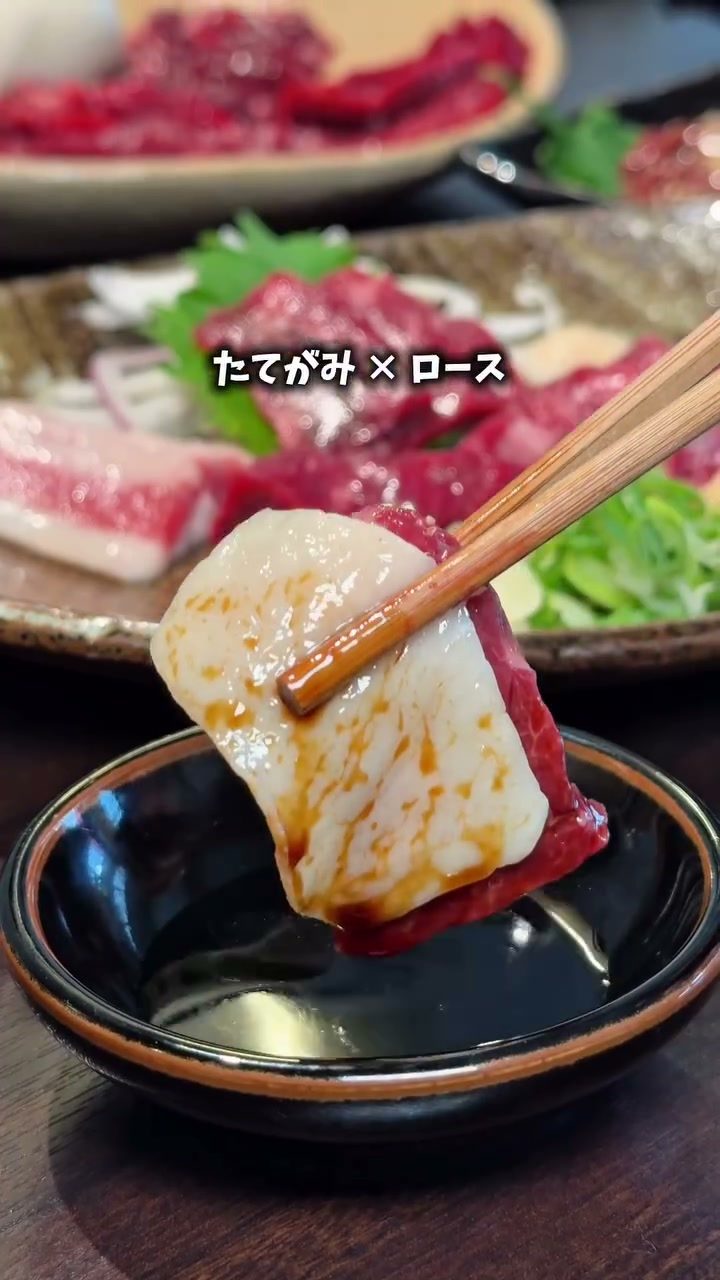 箸で持ち上げたたてがみとロースの馬刺し