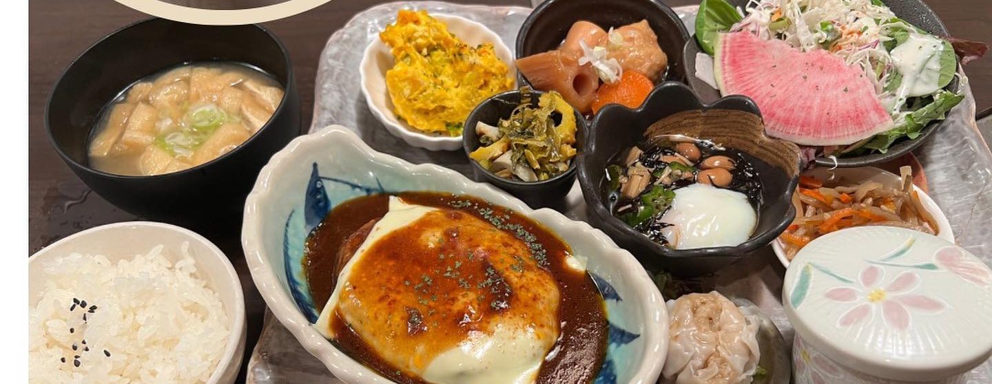 煮込みハンバーグに小鉢やサラダ、ごはん、みそ汁が並ぶランチ