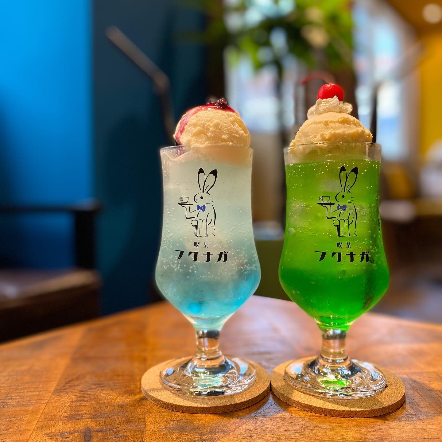 うさぎのロゴ入りグラスに入った青と緑のクリームソーダ