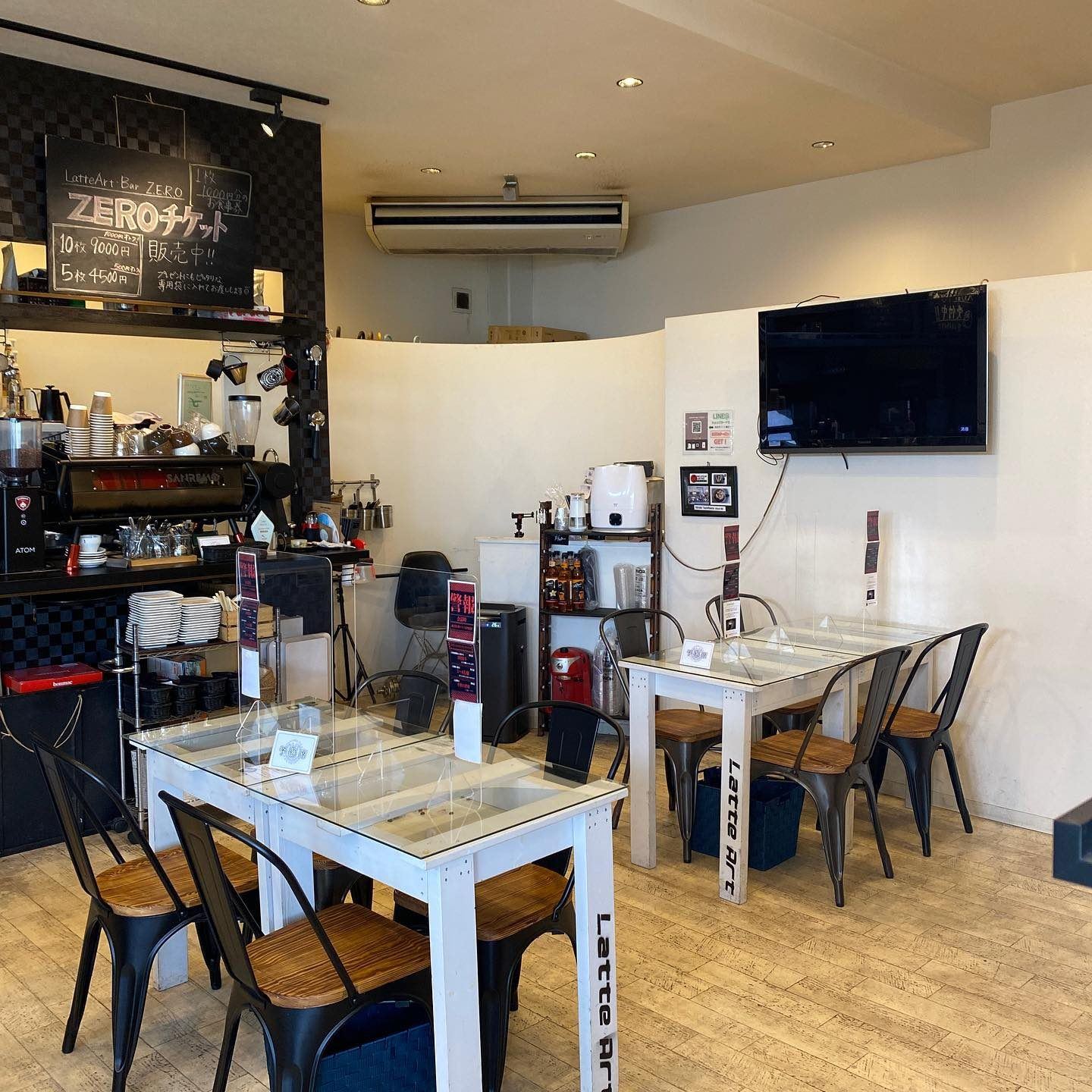 白いテーブルと黒い椅子が並ぶシンプルな店内