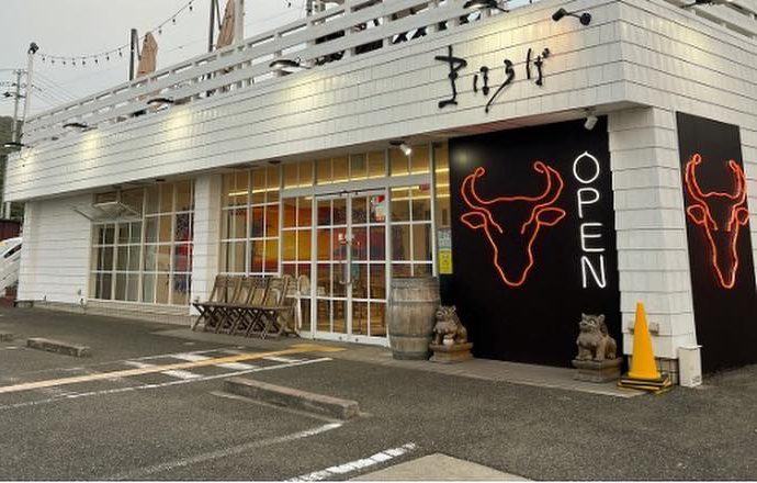 牛のネオンサインが目印の白い外観