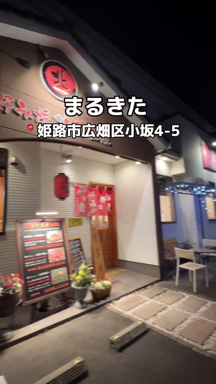 赤い看板と提灯が灯る、夜のまるきたの外観