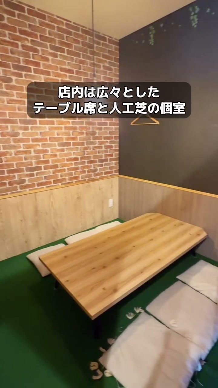 レンガ調の壁に囲まれた人工芝の座敷個室