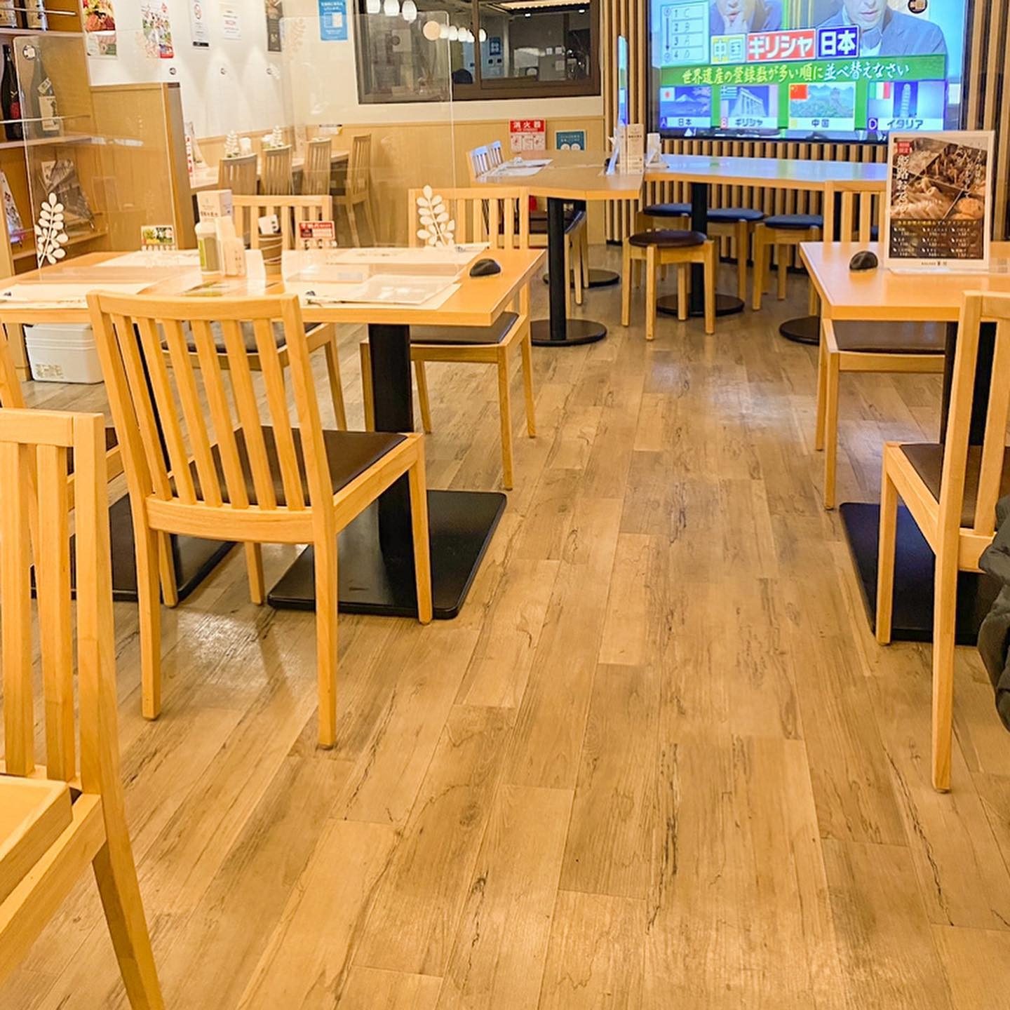 木のテーブルとイスが並ぶ明るい店内