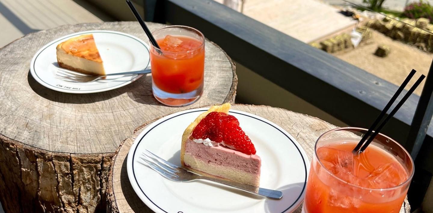切り株のテーブルに並んだいちごのケーキとドリンク