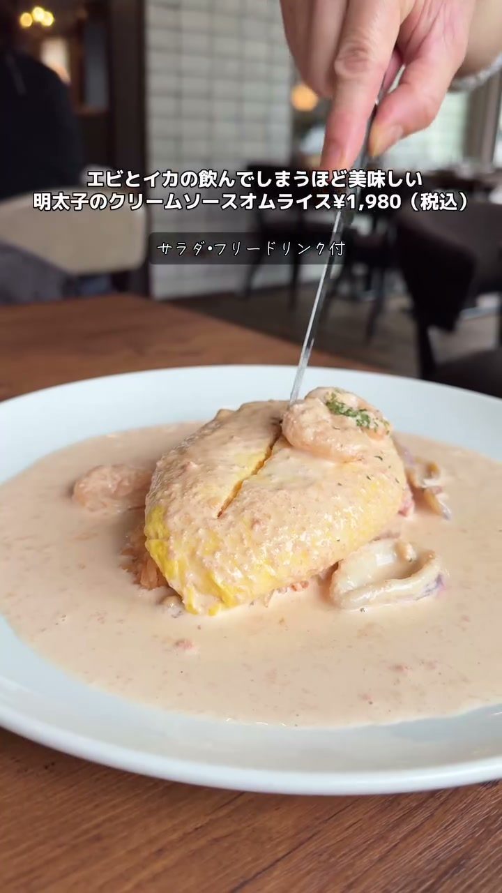 クリームソースがたっぷりかかったエビとイカの明太子オムライス