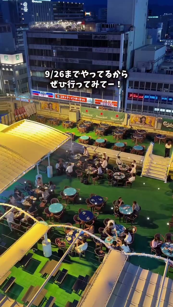 夕暮れの百貨店屋上に広がる人工芝のビアガーデン