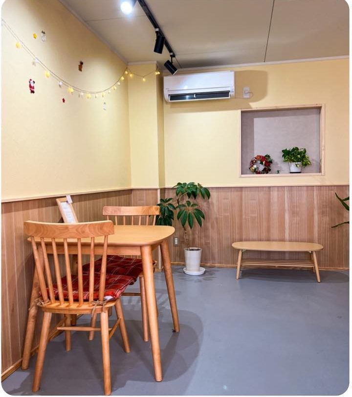 木のイスとテーブルが置かれた明るい店内