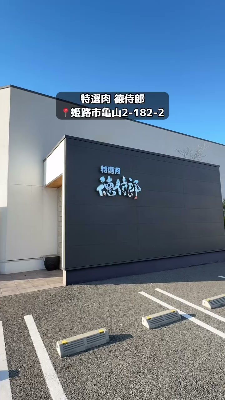 黒い壁に店名が映える徳侍郎の外観と駐車場