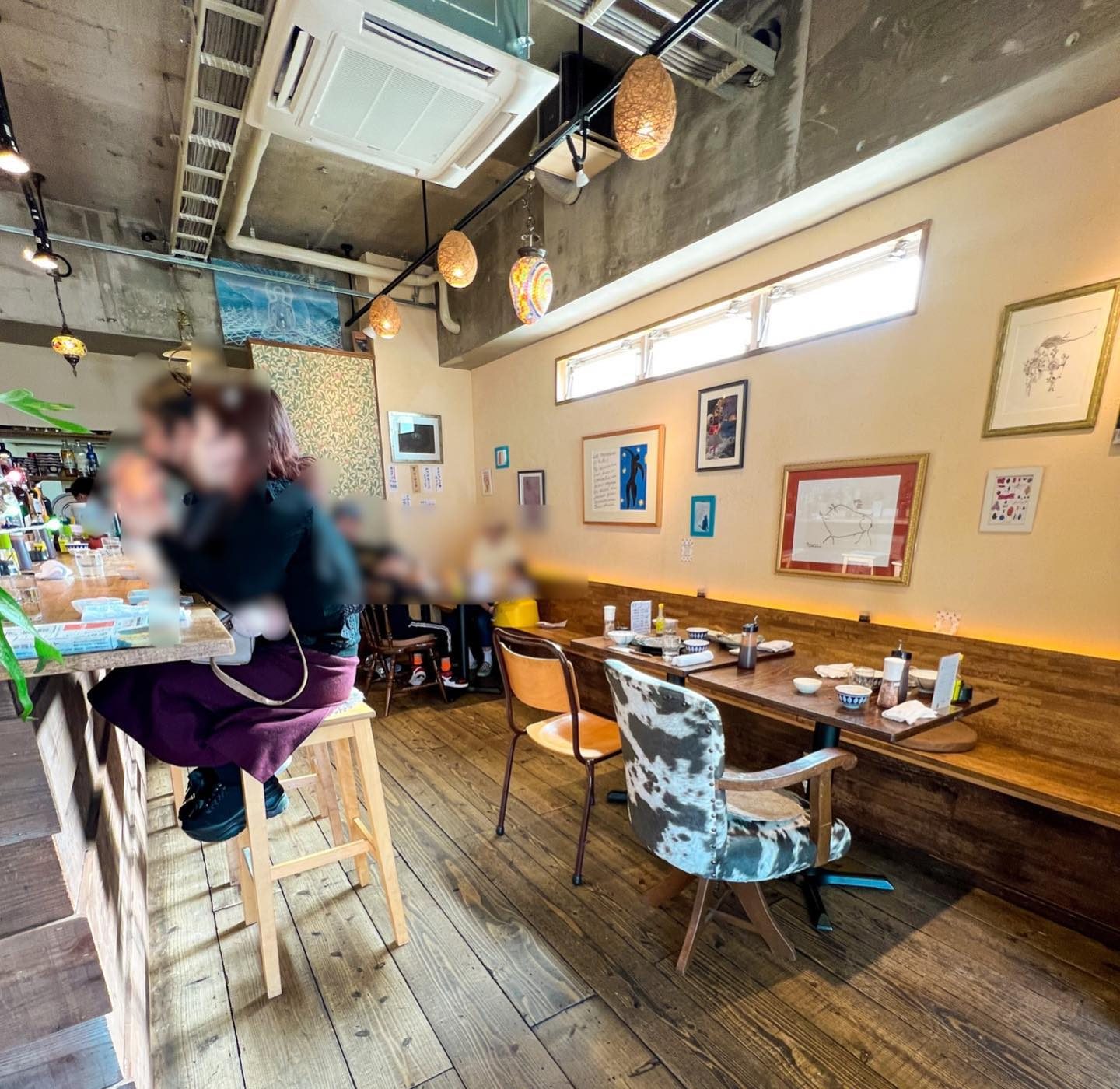 カウンター席とテーブル席が並ぶ木の床の店内