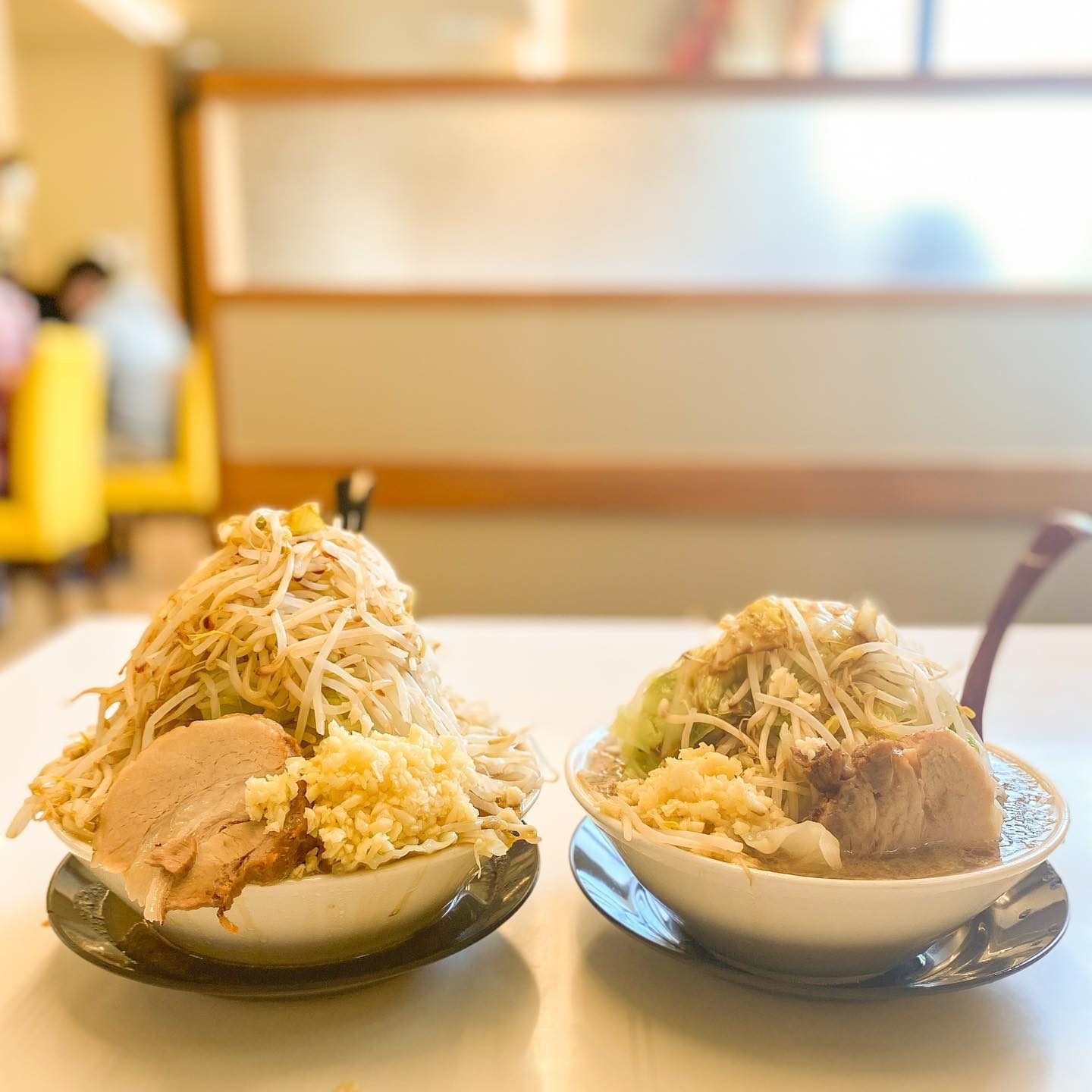 野菜が山盛りになった大盛りと並盛りの二郎系ラーメンの食べ比べ