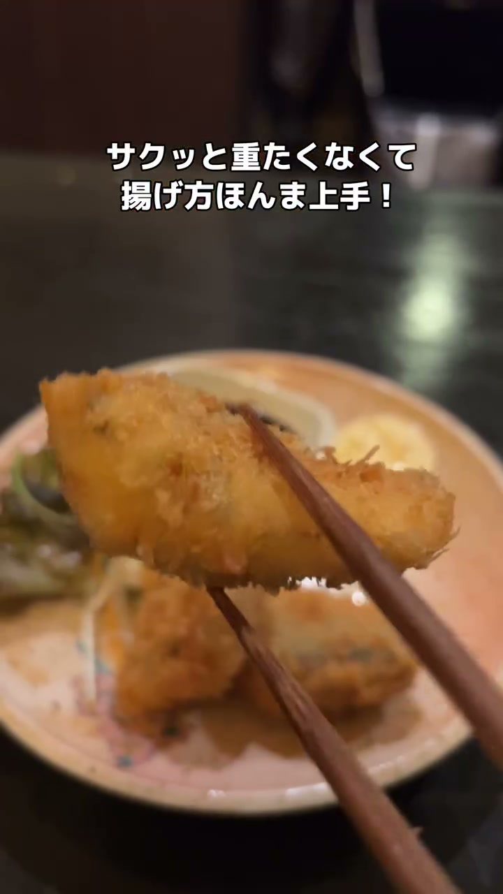 箸で持ち上げた揚げたてのフライ