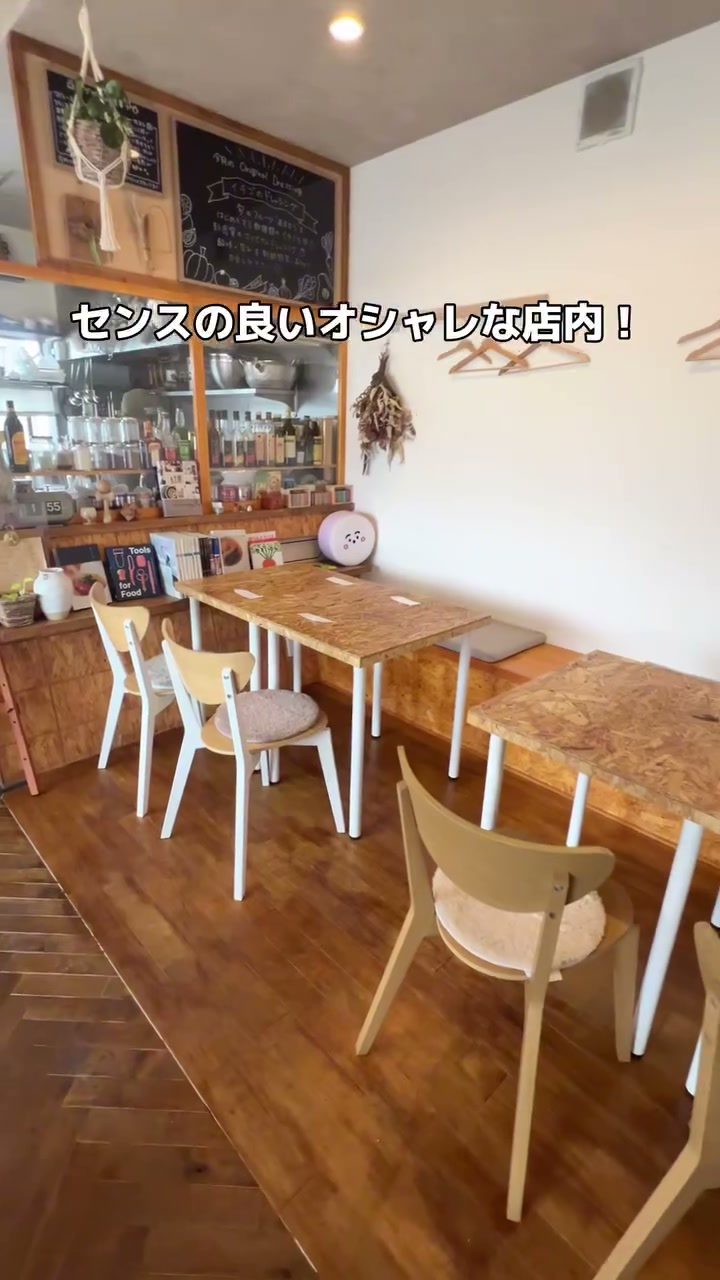 木のテーブルと白い椅子が並ぶおしゃれな店内